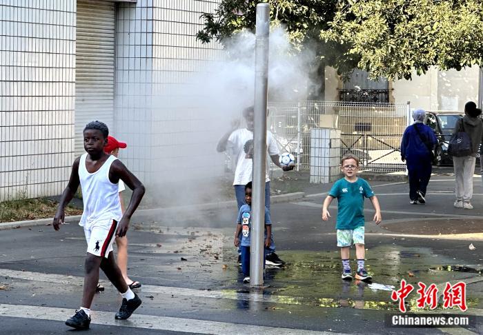 当地时间7月1日，法国巴黎遭遇高温红色警报。图为一群儿童在巴黎郊外的防暑设施周围活动。 中新社记者 李洋 摄